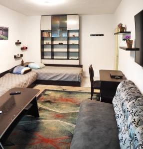 ein Wohnzimmer mit zwei Betten und einem Tisch in der Unterkunft Уютен апартамент в Търговище - 2 спални и кухня in Targowischte