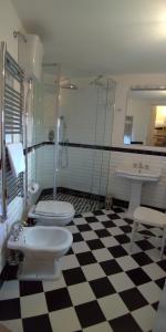 a bathroom with two toilets and a shower and a sink at Casa 3Bien in Matera