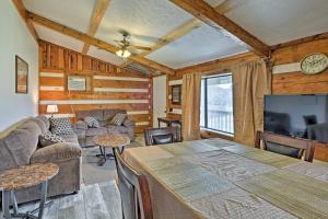 a living room with a couch and a table and a tv at Rogersville Barn Apartment on 27 Acres with Pond! in Rogersville