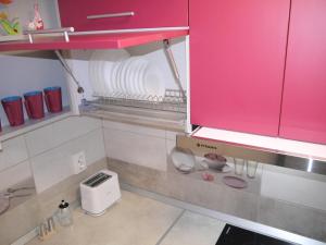 cocina con armario rosa y fregadero en MAGIC HOUSE BRASOV en Brasov