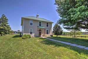 una casa en un campo de hierba con un árbol en Annys Farm House in Round Hill Wine Country!, en Middleburg