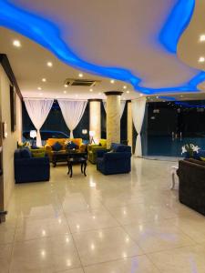 a living room with couches and a blue ceiling at امواج للشقق المخدومة - Amwaj suites in Al Khobar