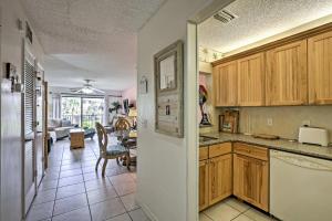 a kitchen with wooden cabinets and a living room at St Augustine Resort Condo - Walk to Crescent Beach in St. Augustine