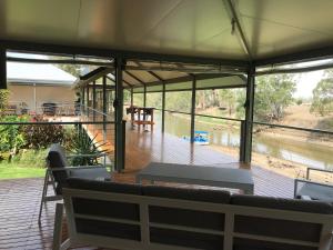 un gran porche cubierto con sofás y una terraza en Riverside Farm Retreat, en Eulah