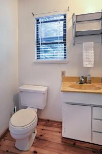a bathroom with a toilet and a sink and a window at Bright Kings Beach Home with Deck Walk to Lakefront in Kings Beach