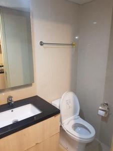 a bathroom with a toilet and a sink and a mirror at #7 Apartemen The Pinnacle - Louis Kienne Pandanaran Semarang in Semarang