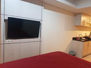 a bedroom with a flat screen tv on a wall at #7 Apartemen The Pinnacle - Louis Kienne Pandanaran Semarang in Semarang