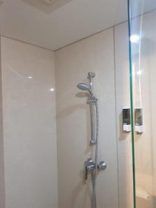 a shower in a bathroom with a glass door at #7 Apartemen The Pinnacle - Louis Kienne Pandanaran Semarang in Semarang