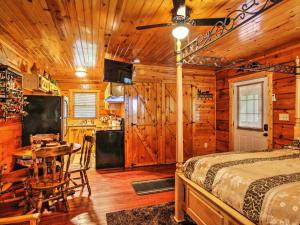 a bedroom with a bed and a table and a kitchen at Log Cabin Studio in Sevierville with Deck and Hot Tub! in Sevierville