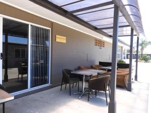 a patio area with chairs, tables, and umbrellas at Dalby Parkview Motel in Dalby