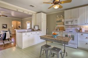 a kitchen with white cabinets and a ceiling fan at Fredericksburg Cottage with Grill - Walk to Main St! in Fredericksburg