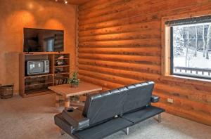ein Wohnzimmer mit einer Couch, einem Tisch und einem Fernseher in der Unterkunft Brian Head Cabin Minutes from Slopes with Game Room! in Brian Head