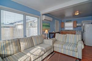 sala de estar con 2 sofás y cocina en Quiet Cottage Less Than half Mi to Gulf Coast and Boardwalk!, en St Pete Beach