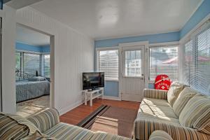 sala de estar con sofá y TV en Quiet Cottage Less Than half Mi to Gulf Coast and Boardwalk!, en St Pete Beach