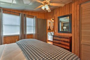 a bedroom with a bed and a mirror and a ceiling fan at Outer Banks Island Cottage - 1 Mi to Frisco Beach! in Frisco