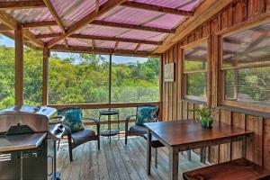 Outer Banks Island Cottage - 1 Mi to Frisco Beach! في Frisco: شاشة في الشرفة مع وجود طاولة وكراسي