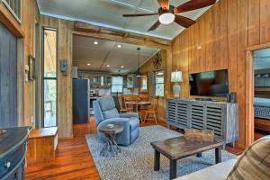 a living room with wooden walls and a ceiling fan at Outer Banks Island Cottage - 1 Mi to Frisco Beach! in Frisco