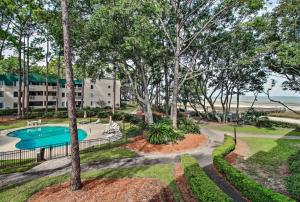 an exterior view of a resort with a swimming pool and trees at Oceanfront Hilton Head Island Condo! in Hilton Head Island