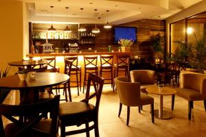 a restaurant with tables and chairs and a bar at Ramot Resort Hotel in Moshav Ramot