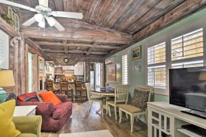 a living room with a ceiling fan and a tv at Driftwood Beach Cottage - Walk to Clearwater Bch in Clearwater Beach
