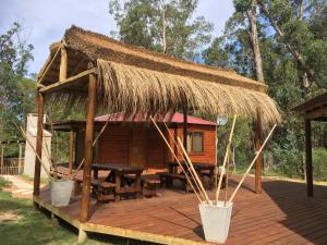 Cabaña con techo de paja y terraza de madera en Los Quetzales, en Maldonado