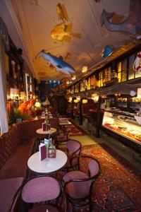 ザンクト・ヴァーレンティーンにあるHotel Kerschbaumerの天井に魚を飾ったテーブルと椅子付きのレストラン