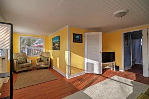 uma sala de estar com paredes amarelas e uma televisão em Treasure Island Cottage, Near Boardwalk and Beach! em St. Pete Beach