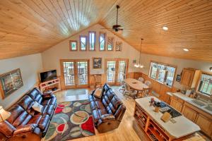 a living room with couches and a table at Rapid River Log Cabin with Loft on 160 Scenic Acres! in Gladstone