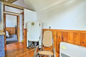 a chair in a room with a refrigerator at Rustic Lakefront Retreat with Shared Dock and Beach! in Rumney