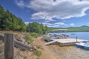 a dock with boats on the shore of a lake at Rustic Lakefront Retreat with Shared Dock and Beach! in Rumney