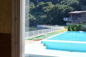 uma vista para uma piscina a partir de uma janela em Sea Tiger Island Inn Shodoshima em Shodoshima