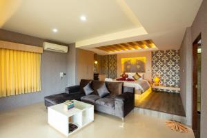 a living room with a couch and a bed in a room at Sita Beach Resort in Ko Lipe
