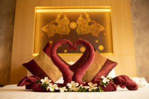 two red swans making a heart on a bed at Sita Beach Resort in Ko Lipe