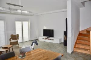 sala de estar con TV, mesa y sillas en Villa Berlin-Seehof, en Teltow