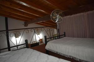 a bedroom with two beds and a fan at Dos ruedas in Mina Clavero