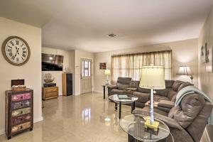 a living room with a couch and a clock on the wall at Updated Lehigh Acres Escape with Private Pool! in Lehigh Acres
