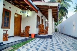 a porch of a house with chairs on it at Amara Guest in Mirissa