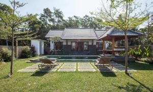 TiTi Villa في Bringkit: منزل فيه مسبح في ساحة