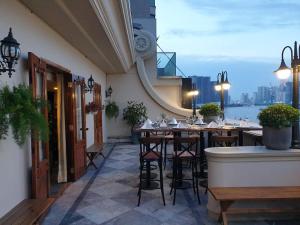 un restaurante con mesas y sillas en un balcón en Riverside Hotel Saigon, en Ho Chi Minh