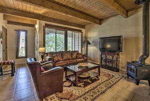a living room with a couch and a table and a tv at Adobe-Style Abode with Amenities - Walk to Plaza! in Santa Fe