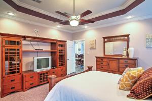 a bedroom with a bed and a tv and a dresser at Waterfront Slidell Home with Boat Dock and Canal View! in Slidell