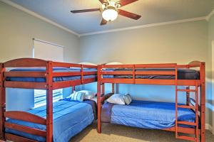 two bunk beds in a room with a ceiling fan at Waterfront Slidell Home with Boat Dock and Canal View! in Slidell