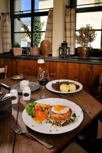 a table with two plates of food and a glass of wine at Matsch - Plauens älteste Gastwirtschaft in Plauen