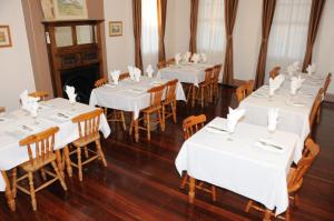 a dining room with white tables and wooden chairs at Railway Bistro - Kandos in Kandos