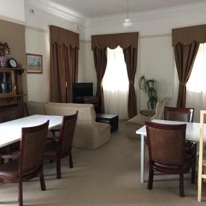een woonkamer met een bank en een tafel en stoelen bij Railway Bistro - Kandos in Kandos