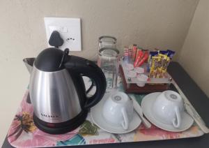 a black and silver tea kettle on a table at La Fiato Luxury Lodge in Dalmada AH
