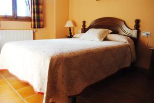 a bedroom with a bed with a white comforter at Casa Rural El Arranca in Riópar