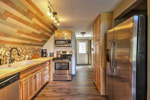 a kitchen with stainless steel appliances and wooden cabinets at Hillside Cripple Creek Cabin with Hot Tub, Mtn Views in Cripple Creek