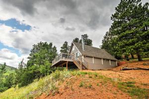a house on top of a hill with a deck at Hillside Cripple Creek Cabin with Hot Tub, Mtn Views! in Cripple Creek
