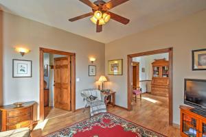 a living room with a ceiling fan and a television at Central Colorado Springs Home with Alluring Backyard in Colorado Springs